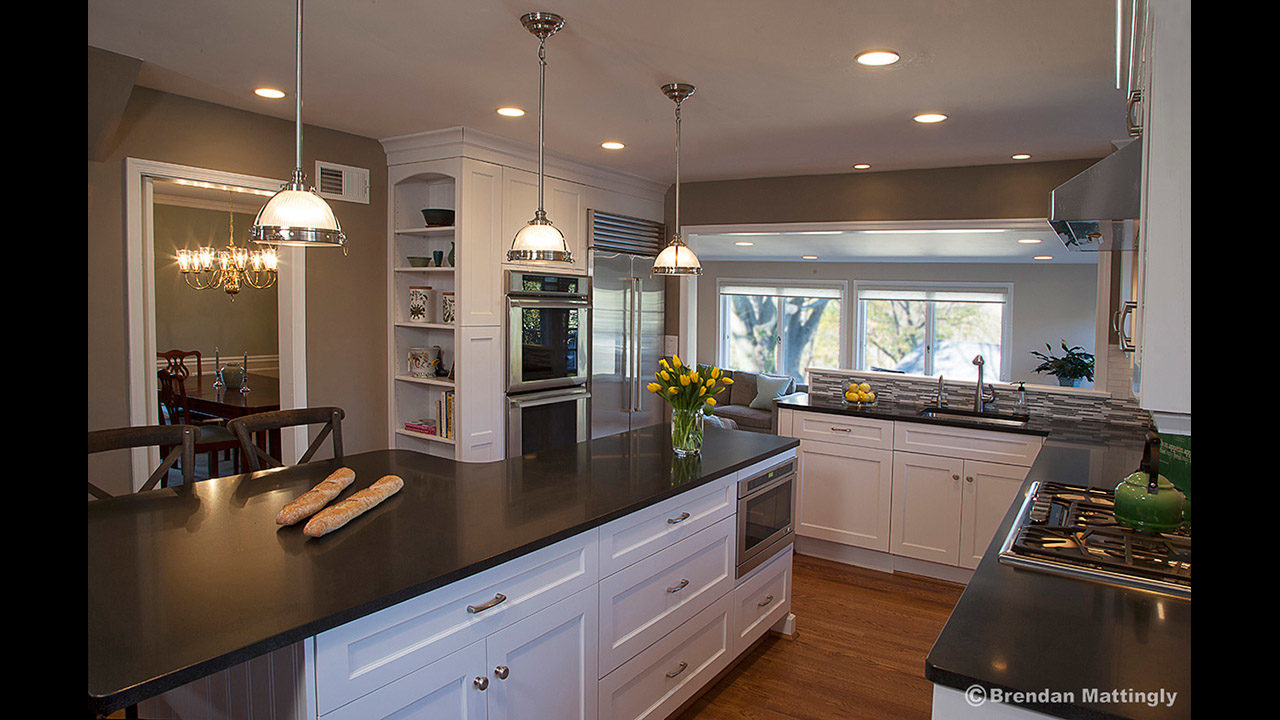 A kitchen with a black counter top and white cabinets.