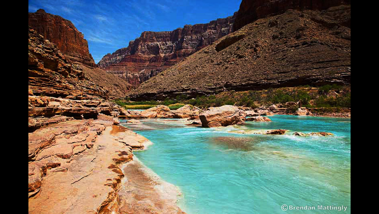 A blue river in the middle of a canyon.