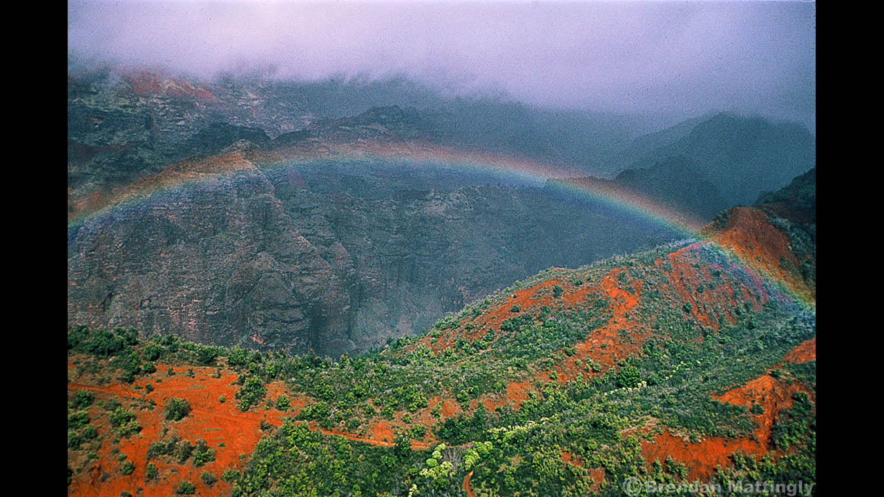 A rainbow is seen over a mountain range in hawaii.