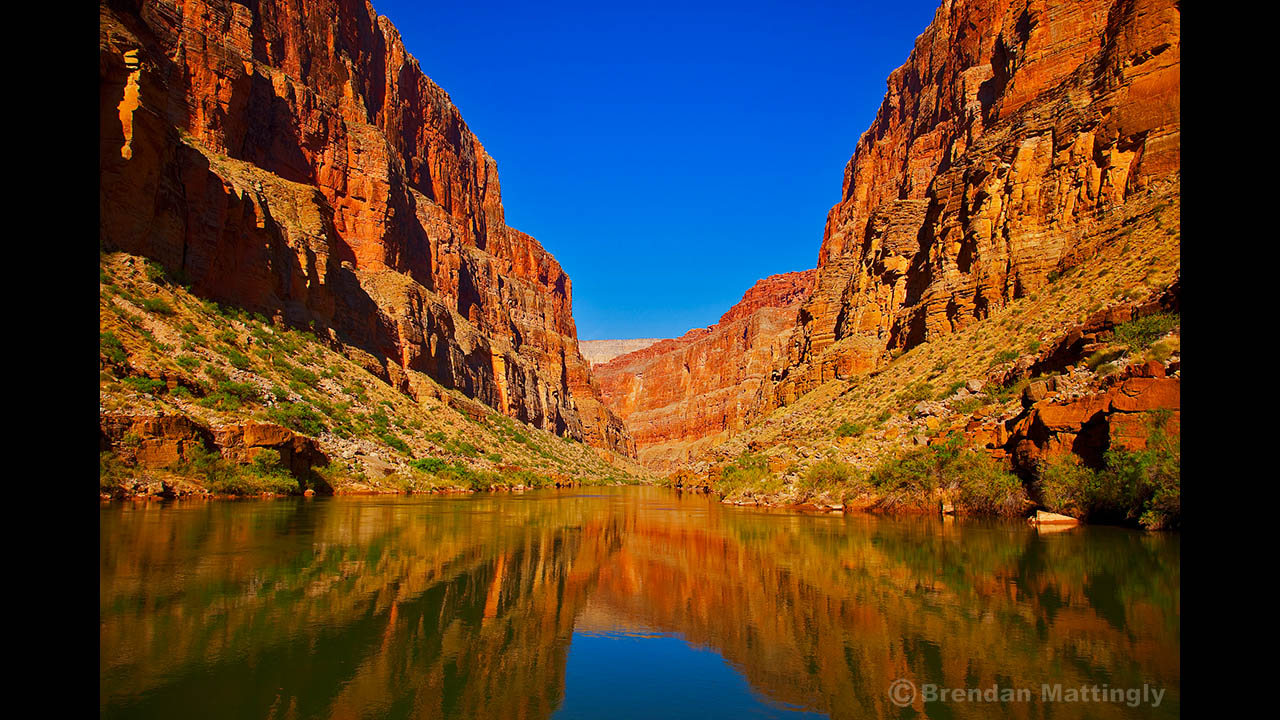 The grand canyon is reflected in the water.